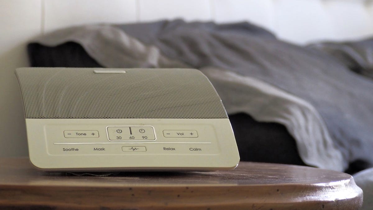 A white noise machine on a bedside table