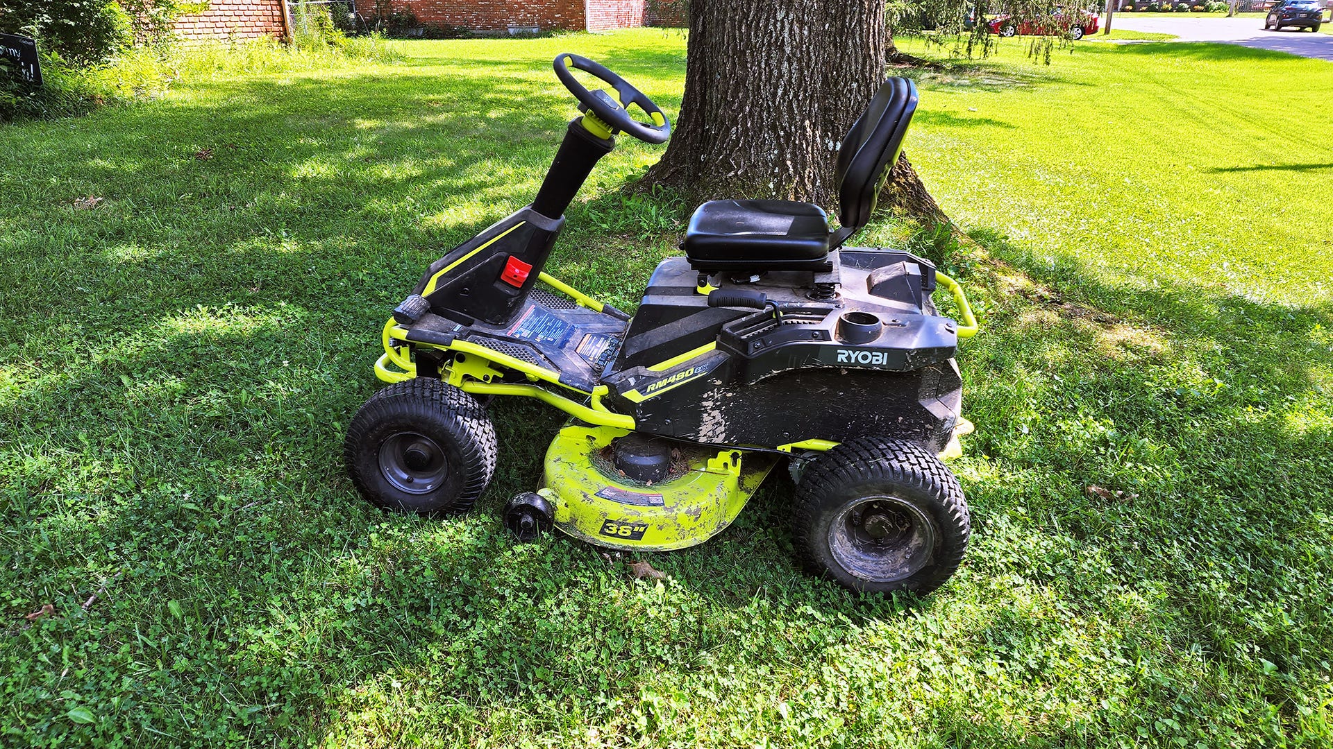 A Ryobi electric lawn mower seen from the side